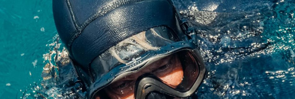 Apnoetaucher mit Kopf aus dem Wasser beim Freediving, nach einem Hood Squeeze beim Freediving