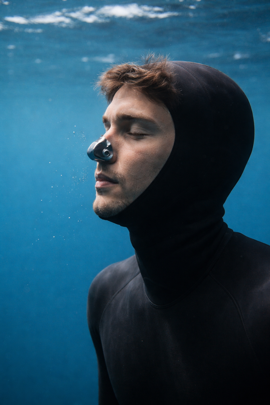 Apnoetaucher trägt Nasenclip beim Freediving, schützt Nase vor Wasser und erleichtert Druckausgleich