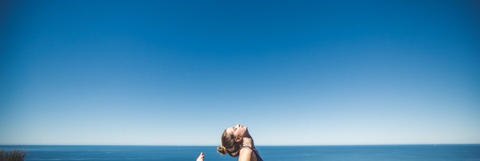 Yoga für Freediver – Frau macht eine Yoga-Übung am Meer zur Verbesserung von Atemkontrolle und Lungendehnung für Freediving